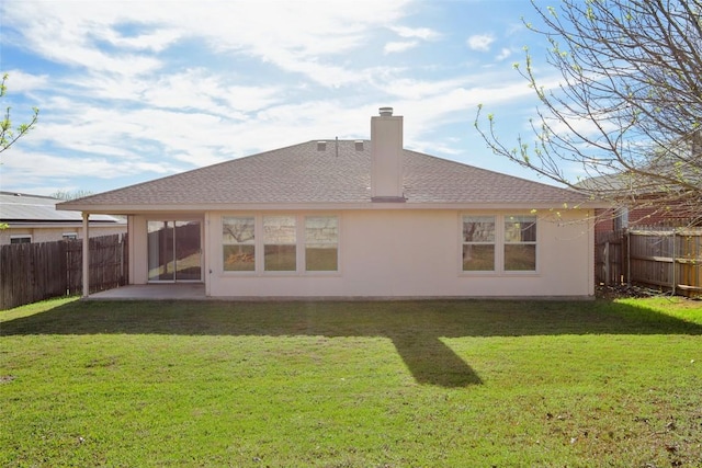 rear view of property with a lawn, a patio, a fenced backyard, roof with shingles, and a chimney