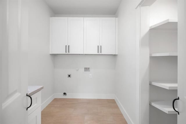 clothes washing area featuring baseboards, washer hookup, hookup for a gas dryer, cabinet space, and electric dryer hookup