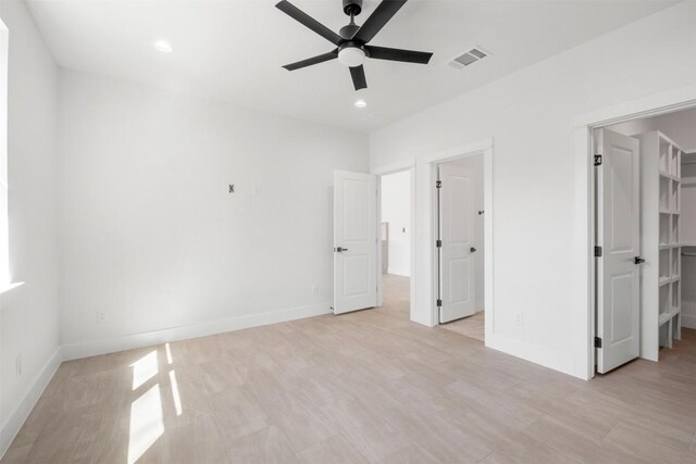 113 Eaglenest Ct, Smithville, TX 78957 - unfurnished bedroom with a walk in closet, light wood-type flooring, recessed lighting, and ceiling fan