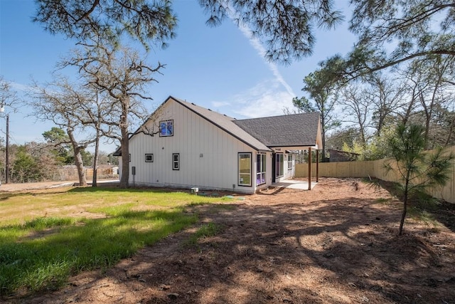 view of home's exterior with fence and roof with shingles