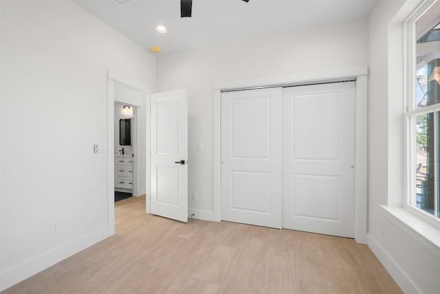 unfurnished bedroom with baseboards, ceiling fan, recessed lighting, light wood-style flooring, and a closet