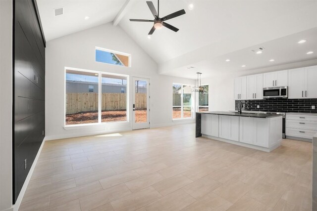 113 Eaglenest Ct, Smithville, TX 78957 - kitchen with stainless steel microwave, dark countertops, beamed ceiling, high vaulted ceiling, and open floor plan