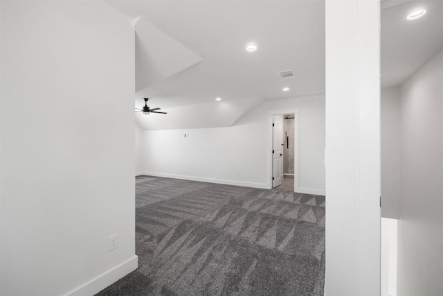 unfurnished room featuring visible vents, baseboards, lofted ceiling, recessed lighting, and dark colored carpet