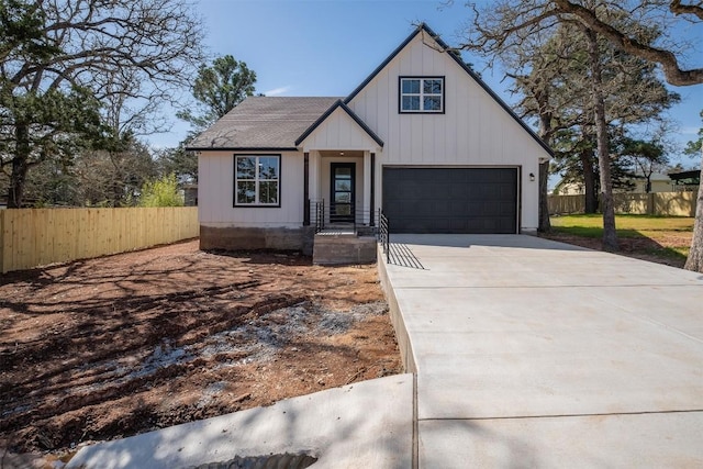 modern inspired farmhouse with concrete driveway, a garage, and fence