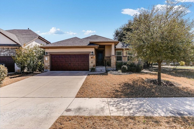 view of front of home featuring a garage, stone siding, concrete driveway, and stucco siding