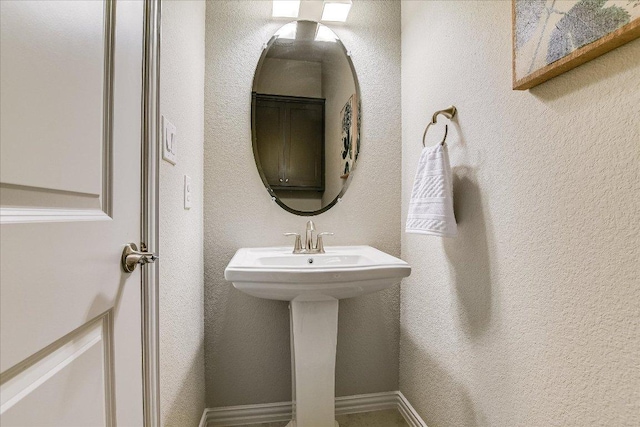 bathroom featuring a sink and a textured wall