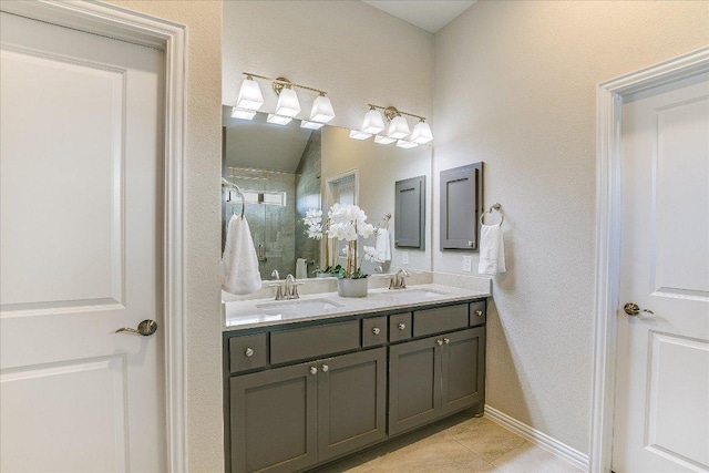 bathroom with a sink, double vanity, a shower stall, and tile patterned floors