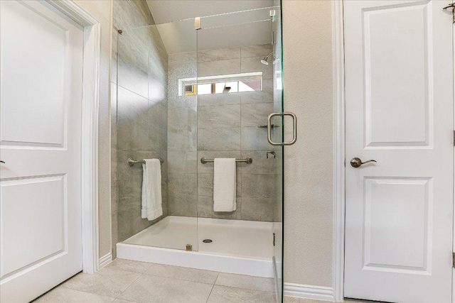 full bathroom with baseboards, a stall shower, and tile patterned flooring