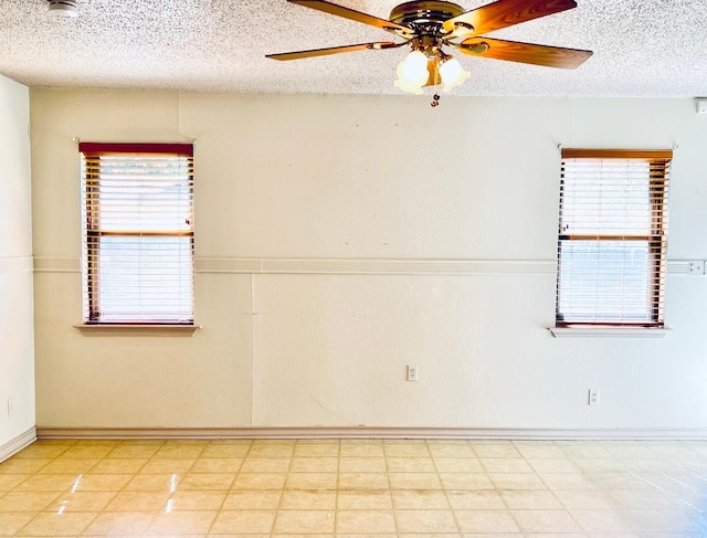 empty room with a textured ceiling and ceiling fan