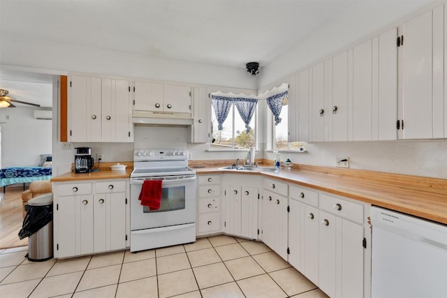 kitchen with white appliances, a wall mounted AC, light tile patterned flooring, a sink, and under cabinet range hood