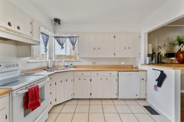 kitchen with white appliances, white cabinets, visible vents, and a sink