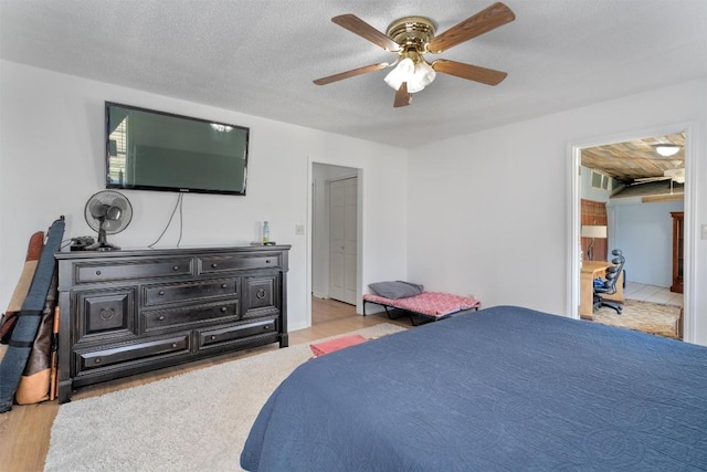 707 Sandy Harbor Dr, Horseshoe Bay, TX 78657 - bedroom with wood finished floors, a ceiling fan, and a textured ceiling