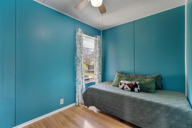 bedroom featuring baseboards, ceiling fan, and wood finished floors