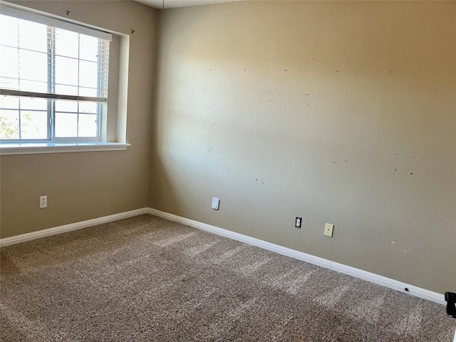spare room featuring baseboards and carpet