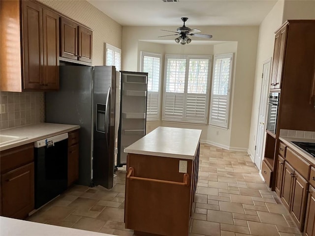 kitchen with tasteful backsplash, baseboards, stone finish floor, black appliances, and a ceiling fan