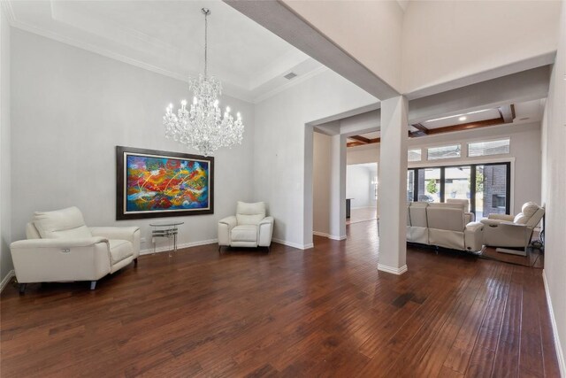 sitting room featuring visible vents, ornamental molding, a towering ceiling, dark wood-style floors, and a chandelier