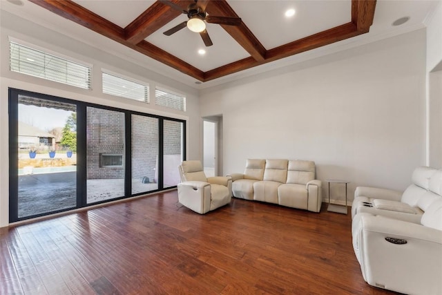 living area featuring crown molding, a ceiling fan, beamed ceiling, and dark wood finished floors