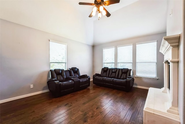 living area with dark wood-type flooring, a ceiling fan, baseboards, and high vaulted ceiling