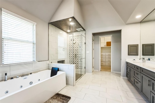 bathroom with double vanity, a tub with jets, a sink, a stall shower, and vaulted ceiling