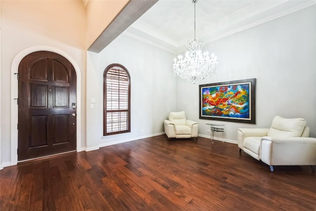 entryway with arched walkways, wood finished floors, baseboards, an inviting chandelier, and ornamental molding