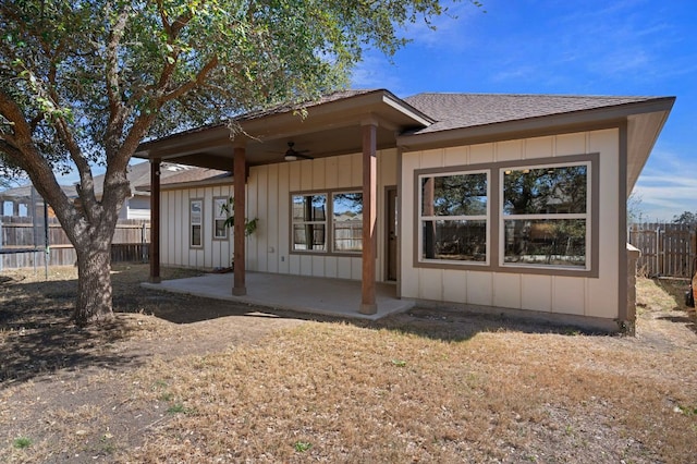 view of front facade with a patio, fence, board and batten siding, and ceiling fan