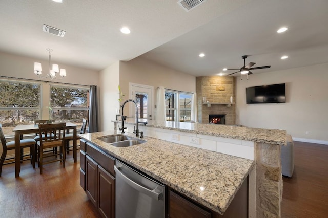 kitchen with dishwasher, a center island with sink, visible vents, and a sink