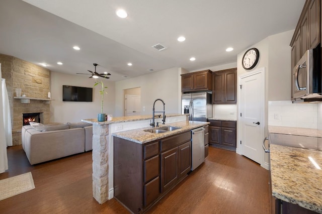 kitchen with a sink, visible vents, appliances with stainless steel finishes, and dark wood finished floors