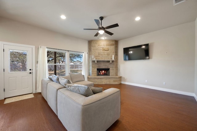 living area with baseboards, ceiling fan, and dark wood-style flooring