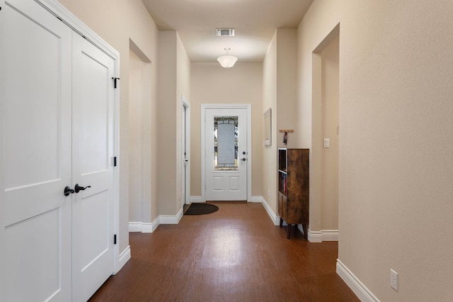 interior space with visible vents, baseboards, and dark wood-style floors