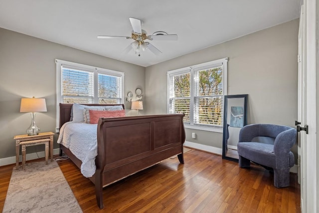 bedroom with hardwood / wood-style flooring, multiple windows, a ceiling fan, and baseboards