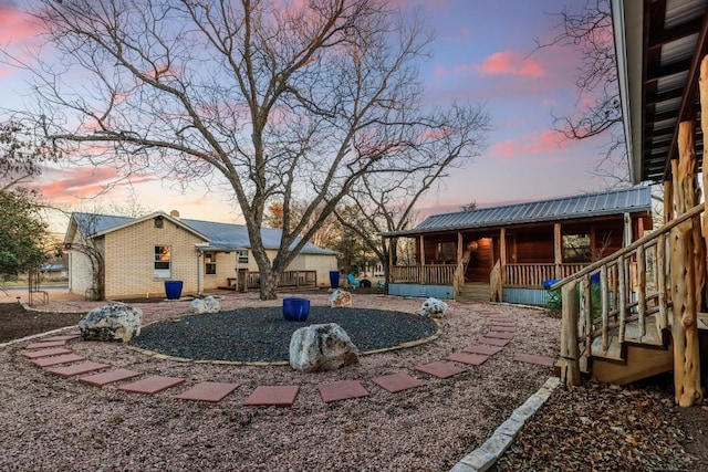 yard at dusk featuring a porch