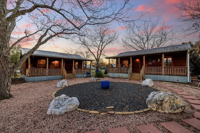 view of front facade with crawl space, covered porch, and metal roof