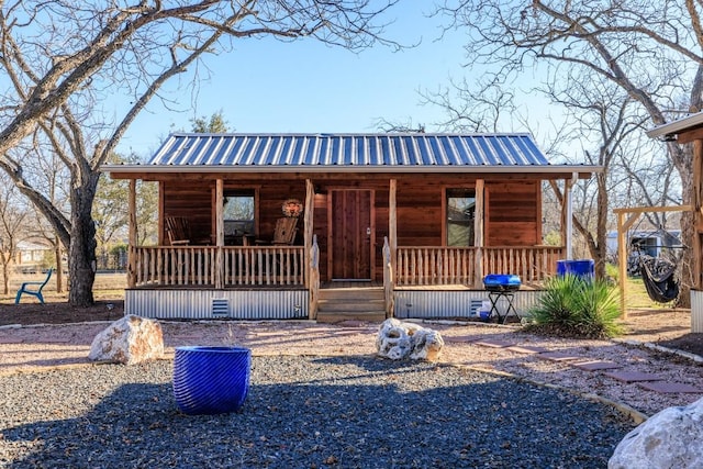 chalet / cabin featuring metal roof and a porch