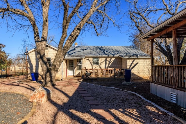 back of property featuring brick siding and a deck