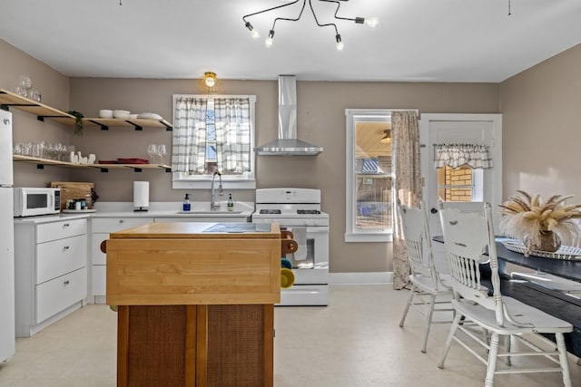 kitchen featuring a sink, white appliances, wall chimney exhaust hood, white cabinets, and light floors