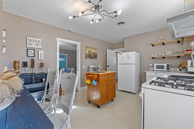 kitchen with white appliances, light floors, visible vents, an inviting chandelier, and brown cabinets