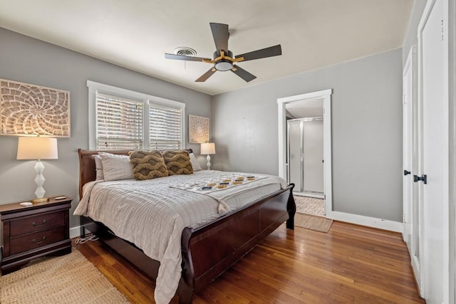 bedroom with wood finished floors, visible vents, baseboards, attic access, and ceiling fan