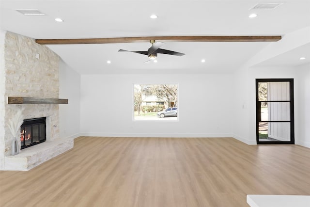 unfurnished living room with lofted ceiling with beams, visible vents, baseboards, and light wood finished floors