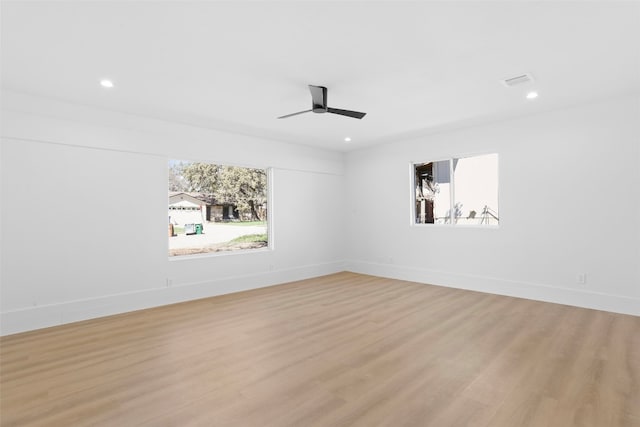 spare room featuring recessed lighting, a healthy amount of sunlight, light wood-style flooring, and baseboards