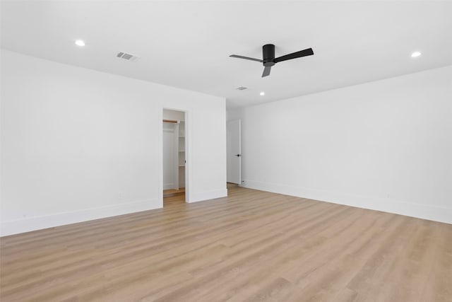 spare room featuring visible vents, baseboards, light wood-style flooring, and a ceiling fan