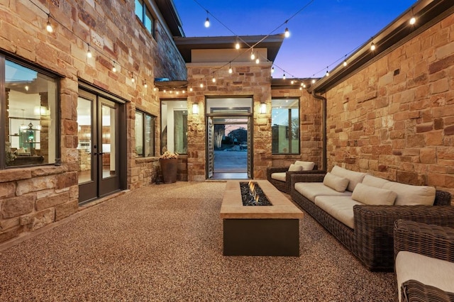 view of patio featuring an outdoor living space with a fire pit and french doors