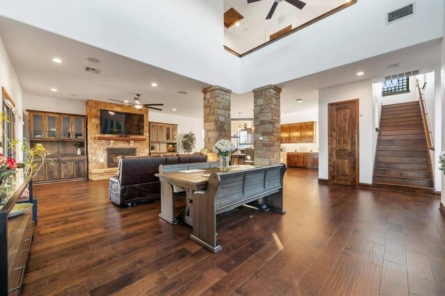 living area with visible vents, dark wood-style flooring, a ceiling fan, and ornate columns