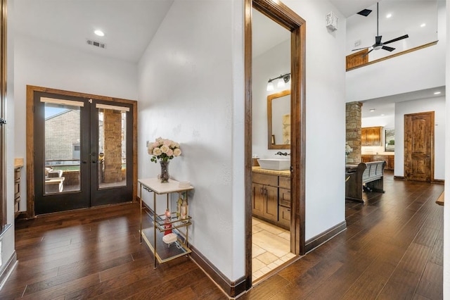 foyer entrance featuring visible vents, a high ceiling, and dark wood-style flooring