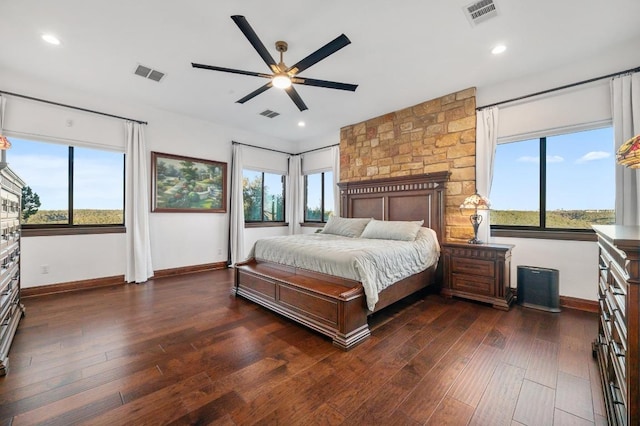 bedroom with visible vents, multiple windows, and dark wood-style flooring