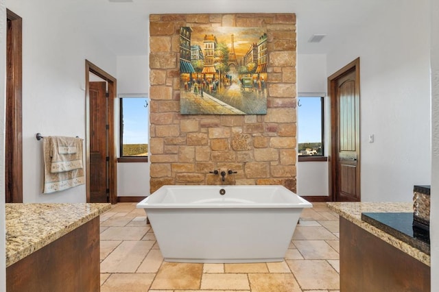 full bath featuring baseboards, a freestanding bath, and vanity