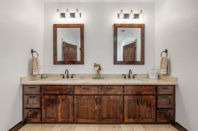 full bath featuring double vanity, baseboards, and a sink