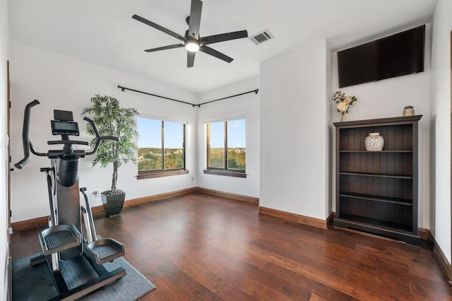 exercise area featuring a ceiling fan, wood finished floors, visible vents, and baseboards