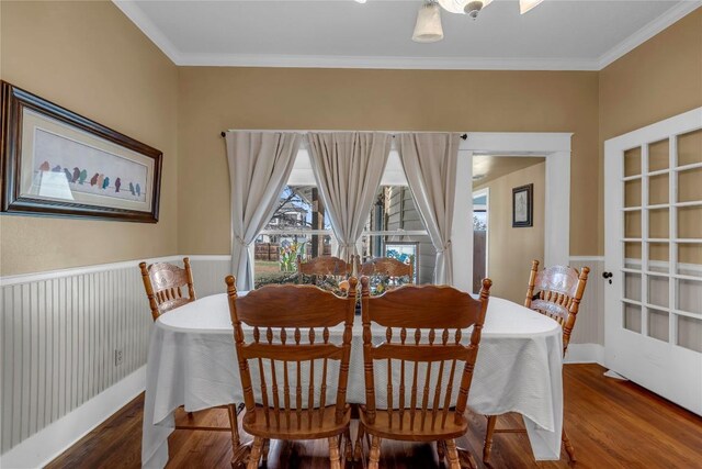 dining area with a wealth of natural light, wood finished floors, wainscoting, and crown molding