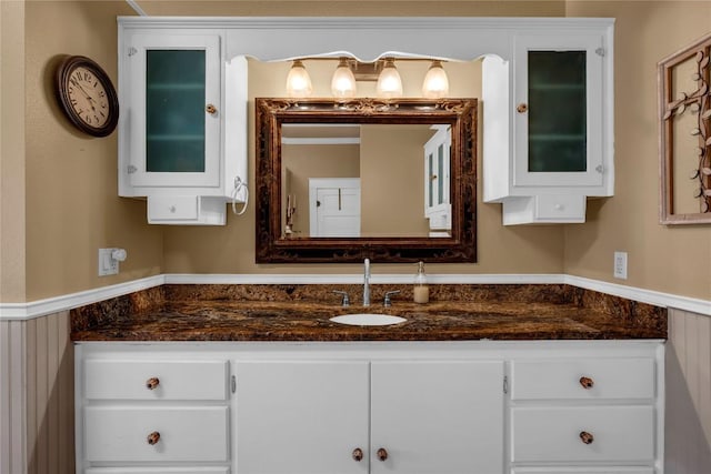 bathroom with vanity and a wainscoted wall