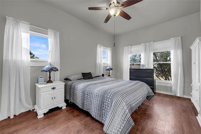 bedroom featuring baseboards, dark wood finished floors, and a ceiling fan